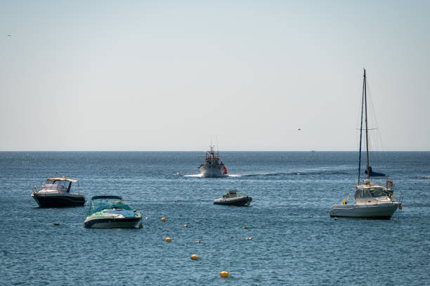 Sesimbra, Portugal - September 10, 2024 : Boats anchored near the harbor on a sunny day by the coast