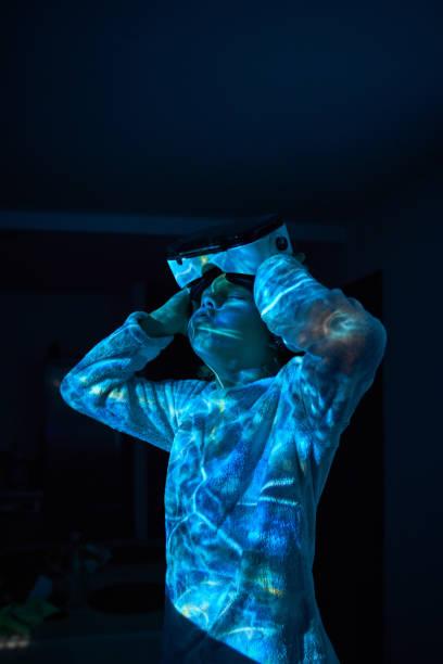 istock Discontent child taking off VR headset after laying video game 2181392375