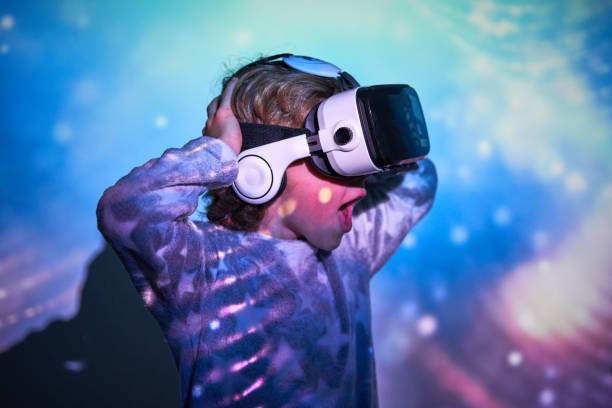 istock Astonished kid in VR headset shouting in illuminated room 2181392390