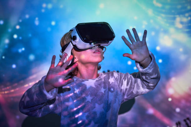 istock Delighted kid interacting with VR glasses in neon lights 2181392398