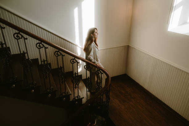 istock Young woman on an ornate home staircase 2181394208