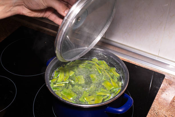 istock man's hand uncovering a pot containing cut green flat beans in boiling water 2181396053