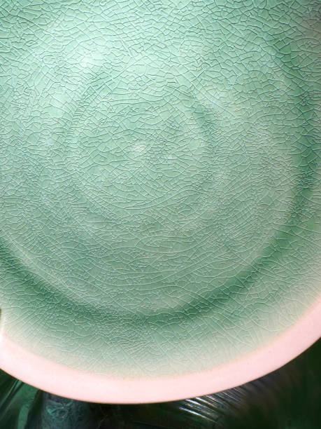Stock photo of ceramic plate showcases a vibrant green crackle glaze, highlighting the unique texture and craftsmanship of the pottery. Ideal for both casual and elegant dining, this dish is part of a beautifully coordinated crockery set