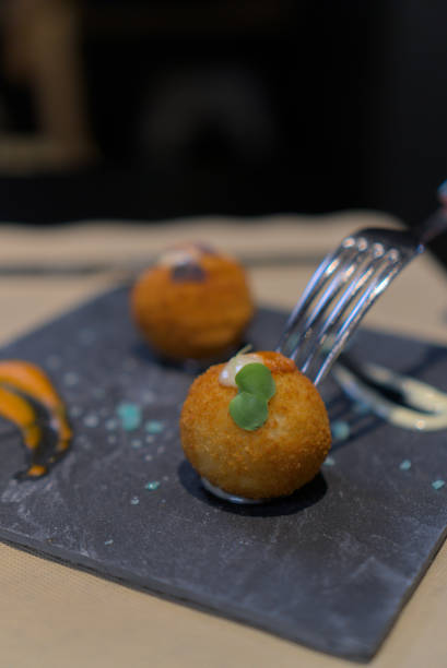istock Fork Approaching Golden Croquette with Creamy Garnish 2181403925