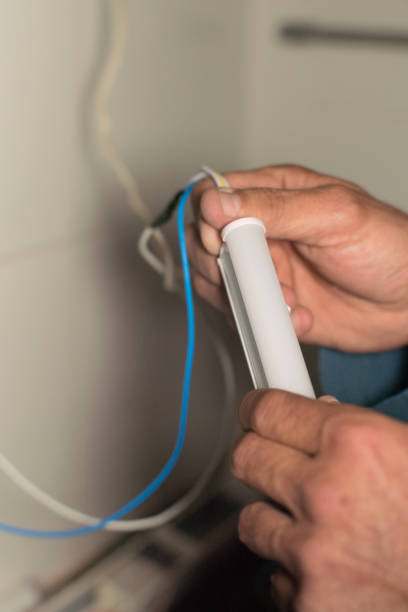 istock Hands of electrician installing led lights. 2181404207