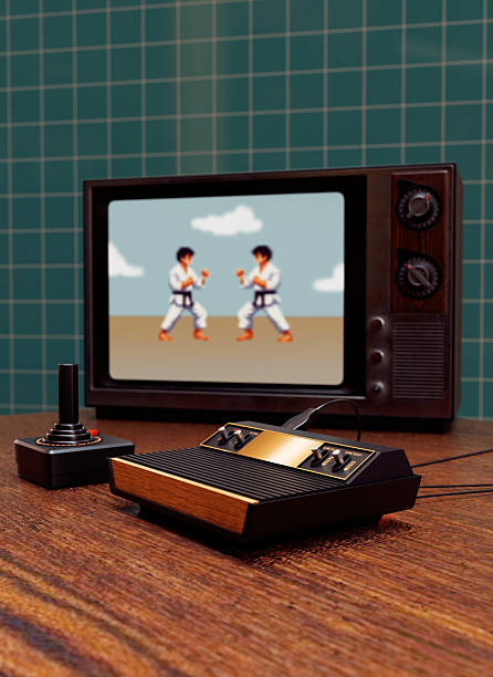 Old-School Gaming: When Pixels and Joysticks Ruled Retro gaming setup featuring an old television displaying a pixelated martial arts fighting game. Two characters in karate uniforms face off on the screen. The setup includes a vintage joystick controller and a classic gaming console, evoking nostalgia for early video gaming eras, especially from the 1980s old-tv-set-console stock pictures, royalty-free photos & images