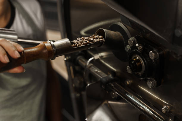 istock Roasting coffee beans process in coffee machine in the production. Fried coffee grains in the facility. Professional coffee bean roasting machine 2181407523