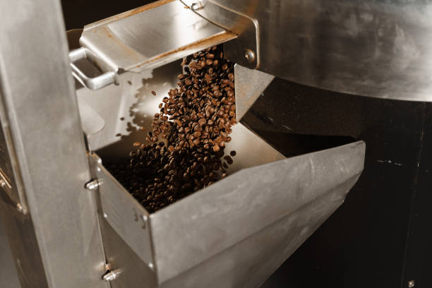 istock Pouring freshly roasted coffee beans after roasting. Professional coffee beans equipment. Coffee roasting process in the facility. 2181407618