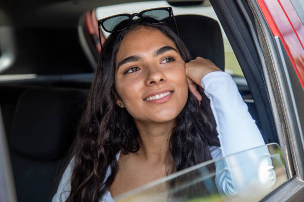 istock smiling young woman inside car looking out the window 2181407956