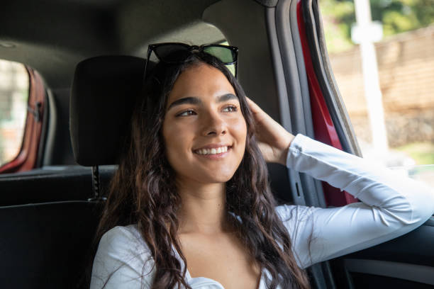 istock smiling young woman inside car looking out the window 2181408014