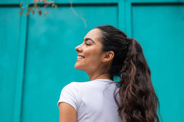 beautiful young woman outdoors with teal background