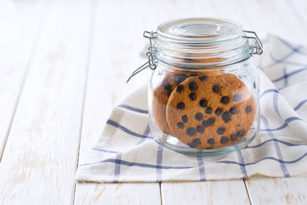 A jar filled with smiley cookies topped with a smiling face, close-up, good mood, homemade baking, uplifting, home comfort and joy.