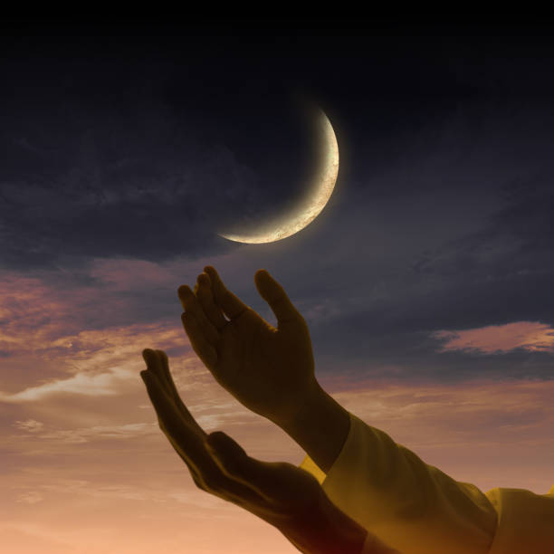 istock Religious Muslim praying while raised hands with crescent moon background 2181427263