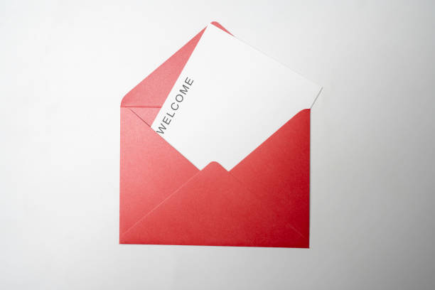 istock Top view of red envelope and postcard with white card with words Welcome on it. Welcome greeting for invitation, express hospitality, greet, show acceptance 2181432817