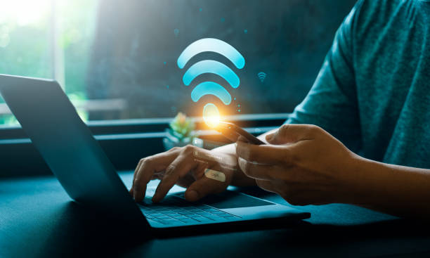 istock Hands Using Mobile Phone and Laptop with Glowing Wifi Icon and Login Screen in Technology Concept. Digital Wireless Internet Connectivity and Secure Access for Online Communication and Data Exchange 2181436558