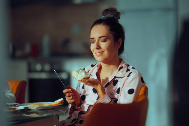 istock Happy Woman Spreading Cream Cheese on Bread for Breakfast 2181437767