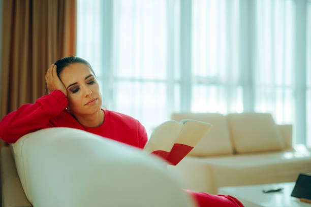 Happy lady feeling comfortable and relaxed holding a novel