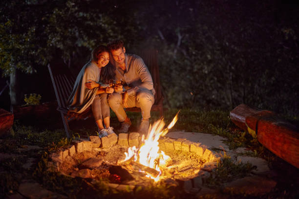 istock Loving couple toasting by the fire during the night in the backyard. 2181449201
