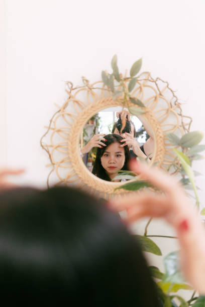 Asian Woman Looking at a mirror