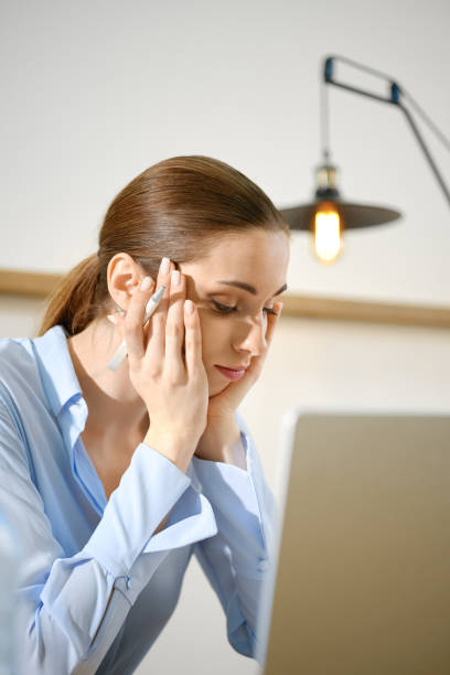 istock A woman experiencing stress while working on her laptop in a modern office setting 2181455020