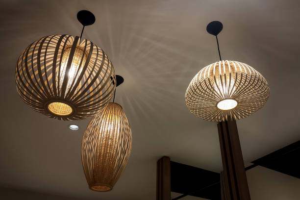 istock Set of three bamboo chandeliers, hung from a ceiling in a subdued atmosphere. 2181455616