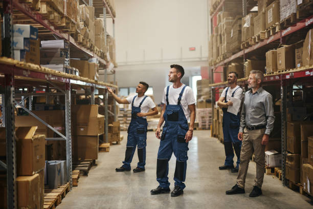 istock Mature manager and workers making plans in storage room. 2181456353