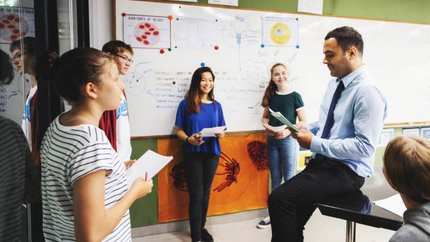 istock Group of students and a teacher in a classroom discussing. 2181457549