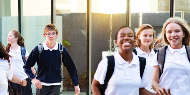 istock Group of happy diverse students in school uniforms walking together. 2181457866