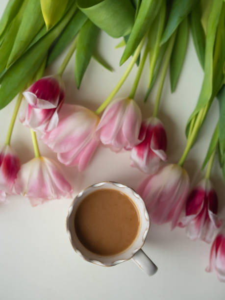 istock White Coffee Mug and Pink Tulips on White, Vertical Flat Lay 2181458302