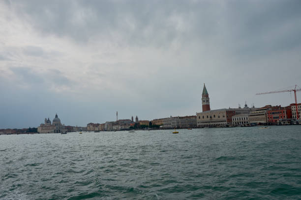 Venice's iconic skyline, featuring the towering St. Mark's Campanile and the historic buildings of St. Mark's Square. This serene image captures the city from a distance, showcasing the tranquil waters of the Venetian lagoon.