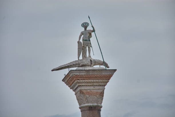 Atop an imposing column in the heart of St. Mark's Square in Venice stands the iconic statue of Saint Theodore. This marble sculpture, depicting the saint standing on a crocodile, is a beloved symbol of the city and a popular subject for tourists and photographers alike