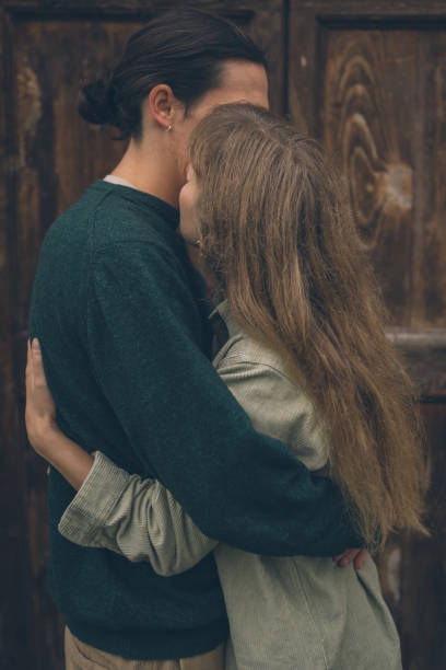 Young man and a woman in affectionate hug, serrious face of a girl