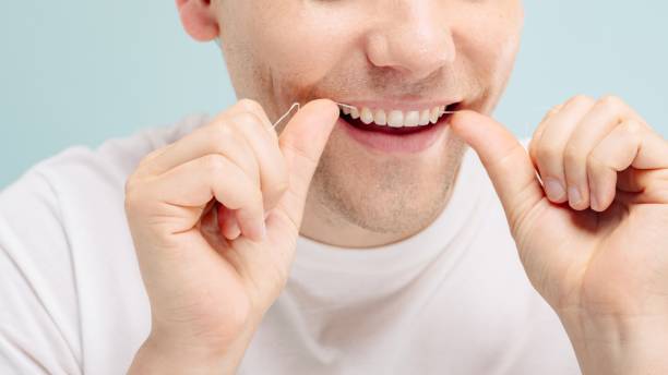 istock Close-up of a person flossing teeth. 2181462625
