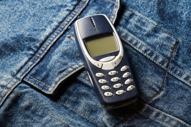 Old-fashioned push-button phone on denim jcket's pocket