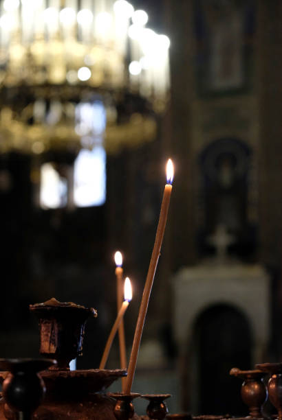 istock Burning candles inside a church with a big candelabra in the background 2181463241