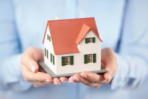 istock Toy house in hands 2181463338