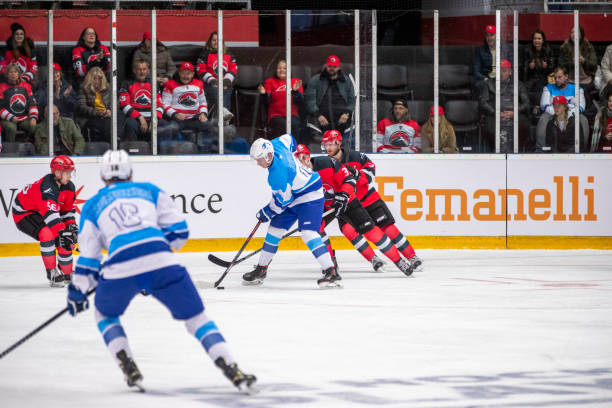 Hockey Players in Intense Puck Battle During Game