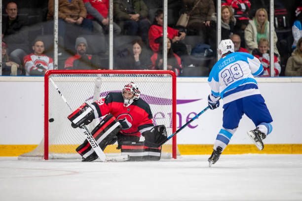 istock Hockey goalie defending net against forward 2181464076