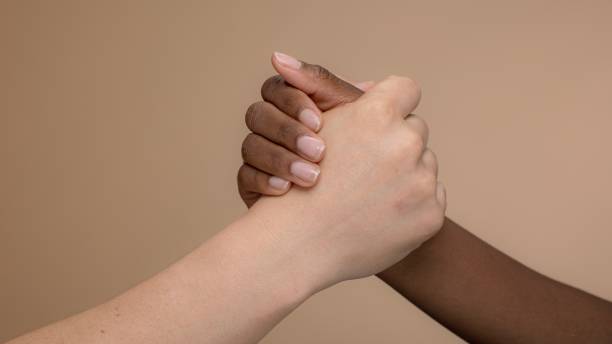 istock Close-up of two diverse hands clasped together. 2181464148