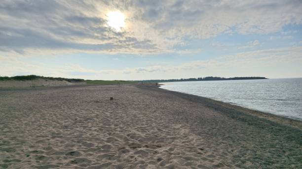 istock Serene beach landscape with a sandy shore, calm sea, and overcast sky 2181465966