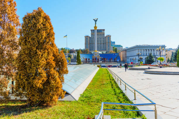 Kyiv, Ukraine - October 9, 2024: Independence Square featuring the Independence Monument and lush greenery, showcasing urban life and architecture in Kyiv under a clear blue sky.
