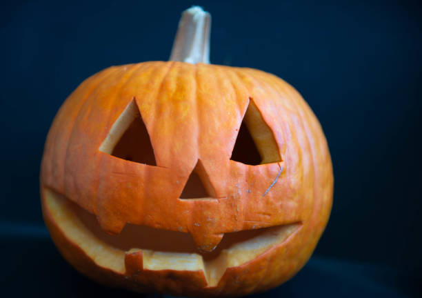 Halloween - ready pumpkin with triangle - shaped eye and nose openings and a toothless mouth opening - photo taken in foreground during the day