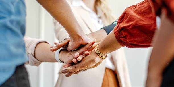 istock Diverse group of business people's hands showing unity and teamwork. 2181470231