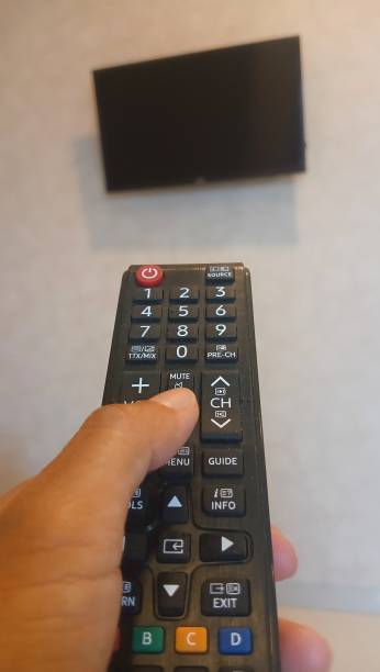 istock hand holding a television remote with a blurred background. 2181473128