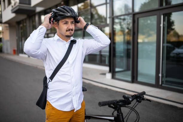 istock Young handsome man is putting a cycling helmet on his head. 2181473649