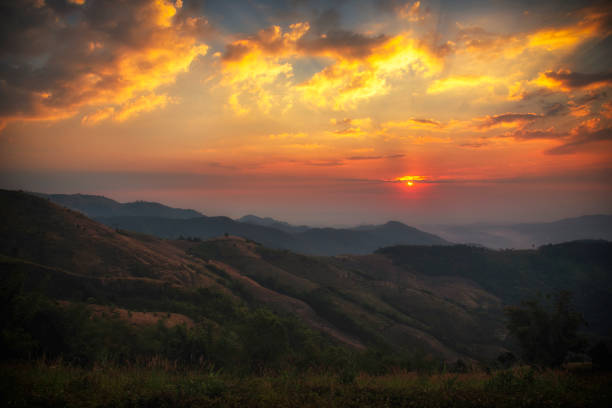 Scenic view dramatic beautiful sunset sky. Natural Sunset Sunrise on meadow silhouette shadow dark land. Vibrant dramatic sky on sunset, dawn, sunrise in Countryside. Landscape Colorful Sky At Sunset