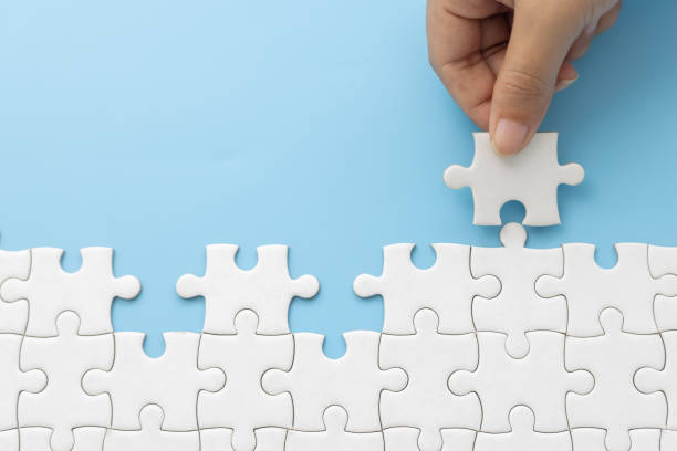 istock Hand push last piece jigsawto finish success planning concept solve puzzle, logical thinking, Concept of challenge and determination as the person works to complete the puzzle. 2181474394