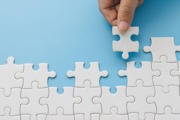 istock Hand push last piece jigsawto finish success planning concept solve puzzle, logical thinking, Concept of challenge and determination as the person works to complete the puzzle. 2181474416
