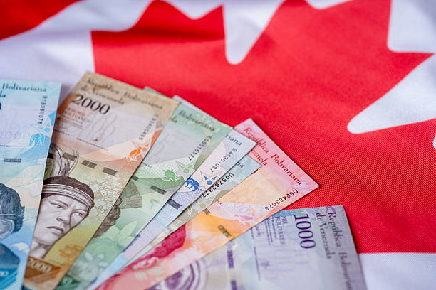 istock Venezuelan Currency Placed on a Canadian Flag 2181475391