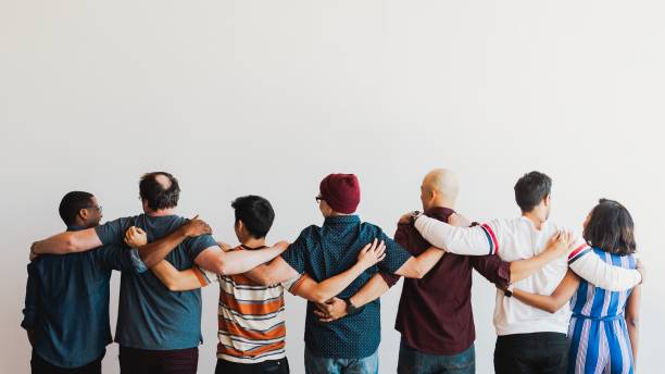 istock Diverse group of people standing together, arms linked. 2181475529